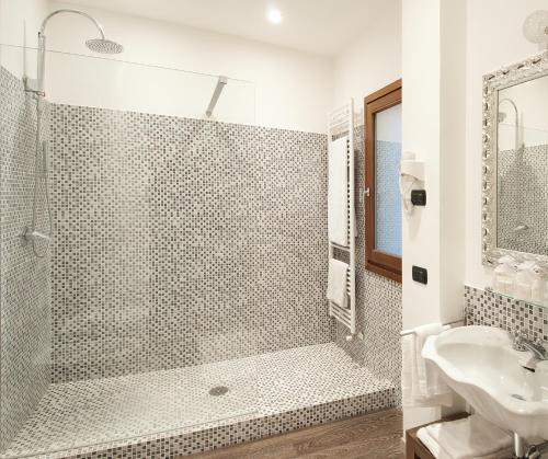 uma casa de banho com um chuveiro e um lavatório. em Bed&Garden em Cesate