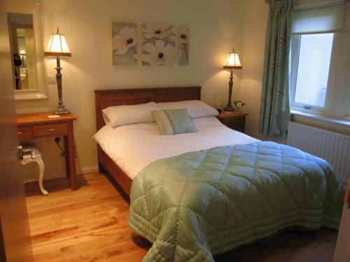 a bedroom with a bed and two lamps and a window at Burrow Meadows in Casterton