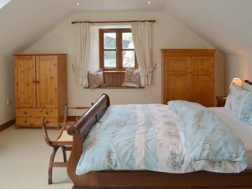 a bedroom with a bed and a window at Apple Tree Cottage -18512 in Kilkhampton