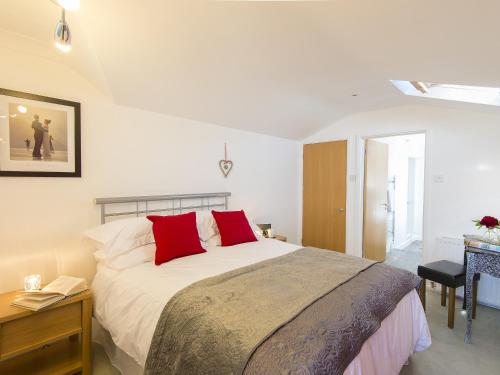 a bedroom with a large bed with red pillows at Florizel in Falmouth