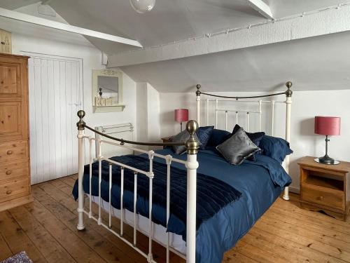 a bedroom with a bed with blue sheets and pillows at The Cottage At Stanley Villa in Southport
