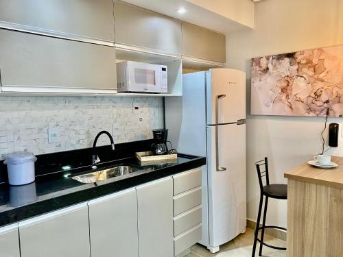a kitchen with white cabinets and a white refrigerator at Apts 501 e 705 Diamond Flats in São Lourenço