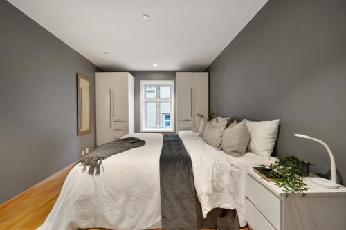 a bedroom with a large bed and a window at Fløyen Lux Apartment in Bergen