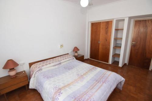 1 dormitorio con 1 cama, 2 lámparas y armario en COMPLEJO TRIUMPH en Mar del Plata