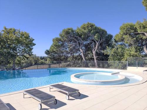 una piscina con 2 sillas y un banco en Escale détente - Résidence 4* au sein d'un Golf en Saumane-de-Vaucluse