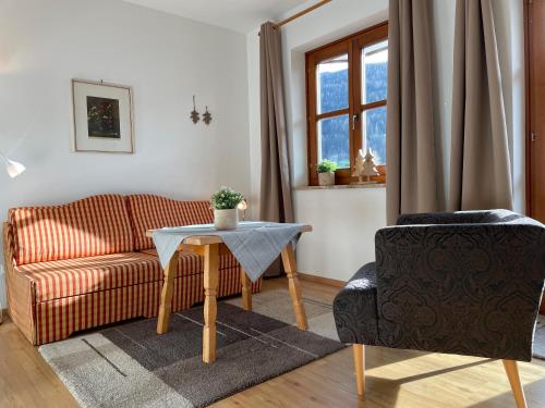 ein Wohnzimmer mit einem Sofa, einem Tisch und einem Stuhl in der Unterkunft Appartements DIANA in Bad Kleinkirchheim