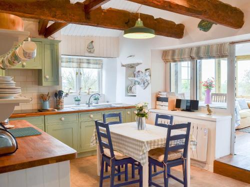 a kitchen with a table and chairs in a kitchen at West Hurscott Cottage in Swimbridge