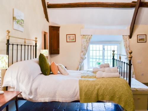 a bedroom with a bed with two stuffed animals on it at West Hurscott Cottage in Swimbridge