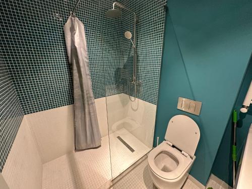 La salle de bains est pourvue d'une douche, de toilettes et d'une cabine de douche en verre. dans l'établissement ATRIUM Mountain View Apartment, New Gudauri, à Goudaouri