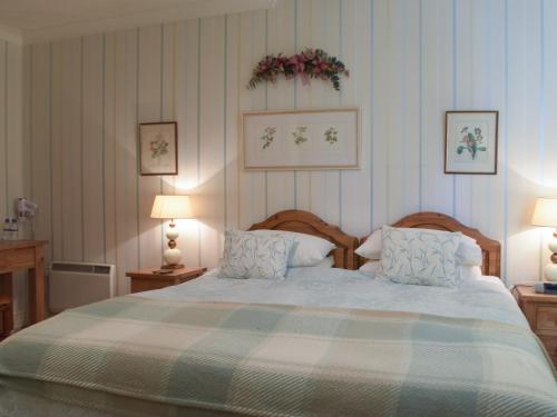 een slaapkamer met een groot bed met 2 kussens bij Carthouse Cottage in Carew