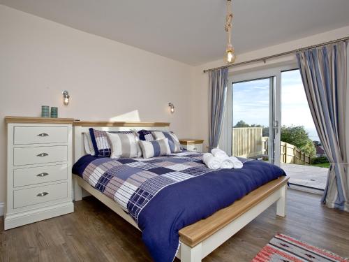 a bedroom with a bed and a window at Orestone Garden Apartment in Dawlish