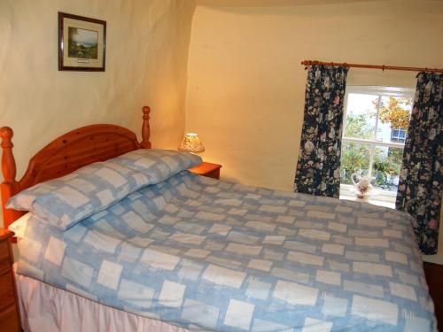 Lobstone Cottage في روسثويت: غرفة نوم بسرير ونافذة