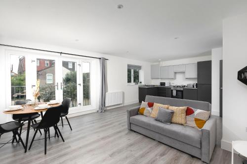 Skyvillion - London Enfield Chase Apartments with Parking & Wifi في انفيلد: غرفة معيشة مع أريكة وطاولة