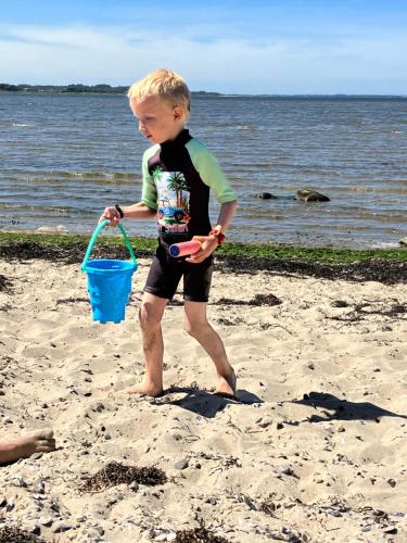a young boy playing in the sand on the beach at Porshus Ferielejlighed in Sundstrup