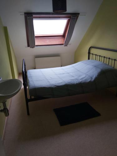 Schlafzimmer mit einem Bett, einem Fenster und einem Tisch in der Unterkunft Brasserie & logies Leopold in Koksijde
