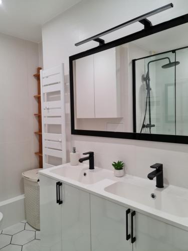 a bathroom with two sinks and a large mirror at Chambre, SDB et salon privés dans appartement 105m2- La Défense in Puteaux