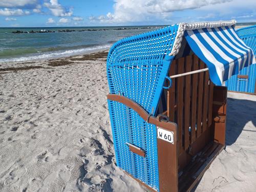 una silla de playa azul sentada en la playa en Oewern Diek 60, en Wustrow