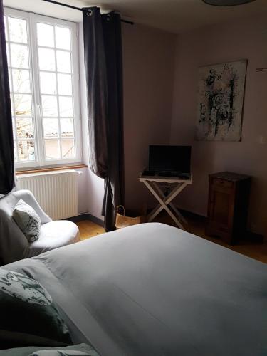 a bedroom with a bed and a desk with a laptop at chambres d'hôtes du Tilleul in Nanteuil-en-Vallée