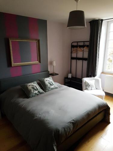 a bedroom with a large bed and a chair at chambres d'hôtes du Tilleul in Nanteuil-en-Vallée