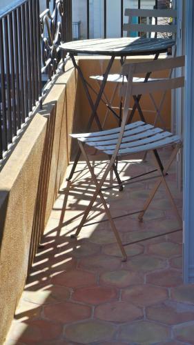 a table and a bench on a balcony at Hotel Relais Du Postillon in Antibes
