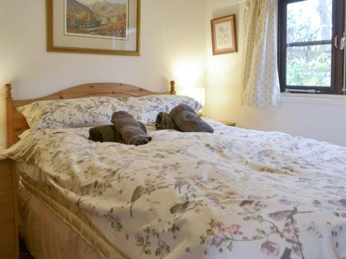 a bedroom with a bed with a floral comforter at Blea Tarn in Elterwater