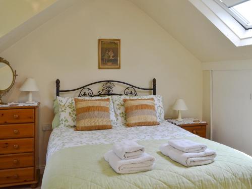 - une chambre avec un lit et des serviettes dans l'établissement The Coach House, à Southampton