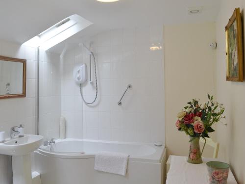 a bathroom with a shower and a sink and a tub at The Coach House in Southampton