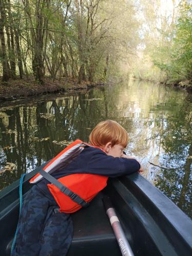 a young boy in a boat on a river at Logis de LANGE studio 2 p in Saint-Hilaire-la-Palud