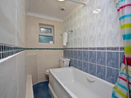 uma casa de banho com banheira e WC em 1 Roundham Heights em Paignton