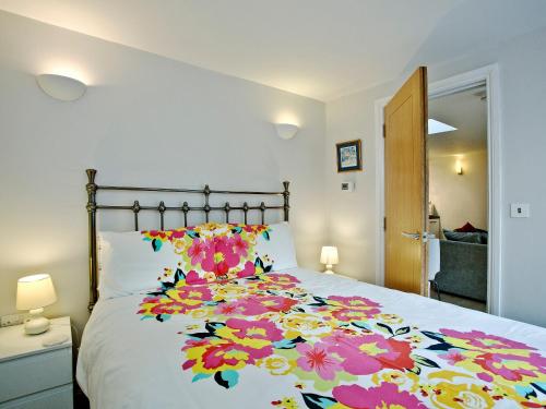 een slaapkamer met een groot bed met bloemen erop bij Little Gem in Weymouth