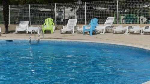 a group of chairs sitting next to a swimming pool at camping domaine des iscles in La Roque-dʼAnthéron