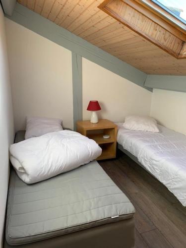une chambre avec deux lits et une table avec une lampe dans l'établissement MAISON LANDES OCEAN, à Saint-Julien-en-Born