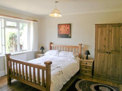 a bedroom with a bed and a dresser and a window at Farthngs in Boxted