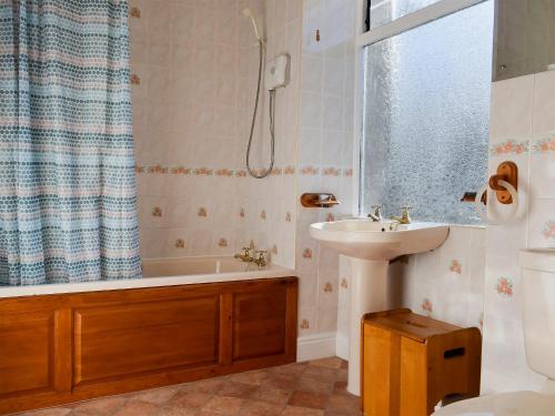 y baño con bañera, lavamanos y ducha. en Alexandra Cottage, en Windermere