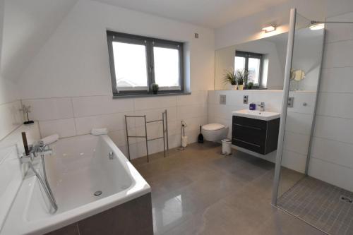 uma casa de banho com uma banheira, um lavatório e um WC. em Ferienhaus Cappuccino auf der Insel Rügen em Lauterbach