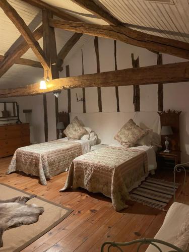 two beds in a room with wooden floors at Les Galineaux in La Roquille