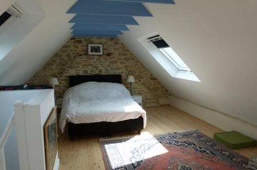 a bedroom with a bed in a attic at La maison de Jeanne in Pont-Croix