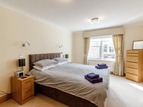 a bedroom with a bed with purple towels on it at Orchard Sands in Beadnell