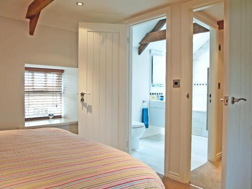 a bedroom with a bed and a bathroom with a toilet at The Granary - 26502 in High Etherley