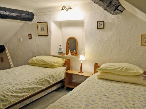 a bedroom with two beds and a table with a lamp at Pats Cottage in Dore