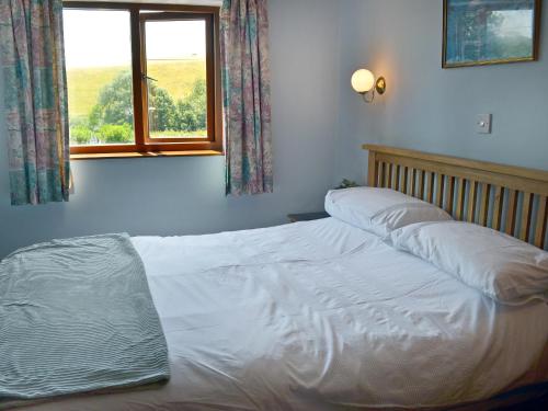 a white bed in a bedroom with a window at Champernowne in Darlington