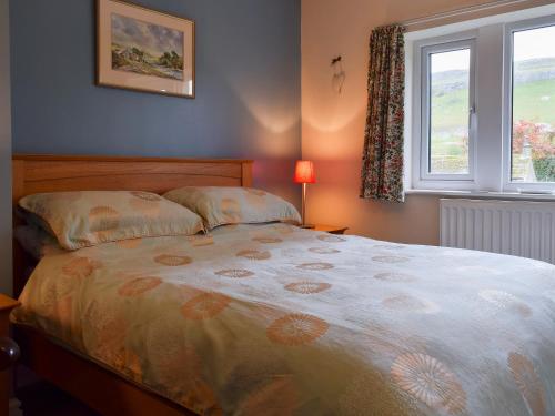 a bedroom with a bed and a window at Fell View in Kettlewell