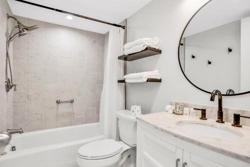 een badkamer met een wastafel, een toilet en een spiegel bij Paralia Condo in Clearwater Beach