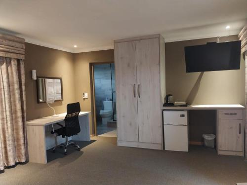 um quarto com uma secretária e um armário com um computador em Mourice Lodge em Sterkspruit