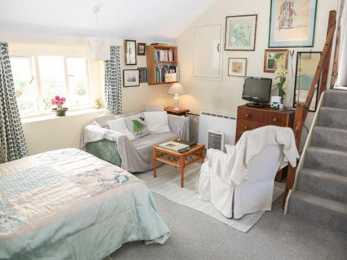 a bedroom with a bed and a chair and a staircase at Garden Flat in Pilton