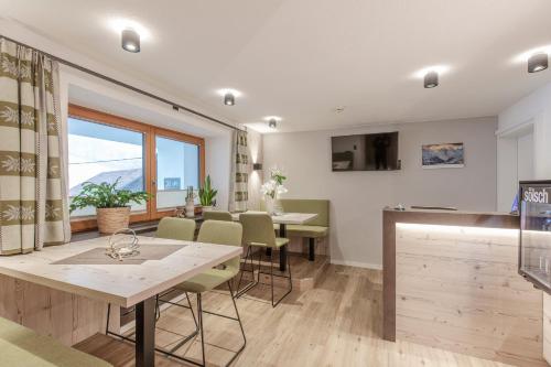 a kitchen and dining room with a table and chairs at Hotel Garni Schönblick in Sölden