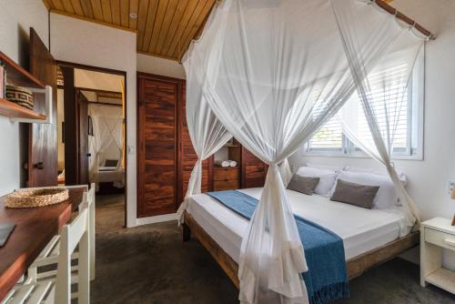 um quarto com uma cama e uma rede mosquiteira em Casa Shaka em Atins