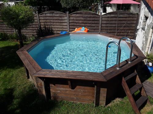 a hot tub in a backyard with a wooden deck at La Maison de Sylvie, chambres d'hôtes à Tarbes in Tarbes
