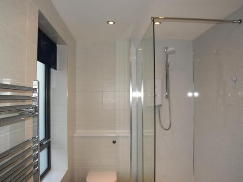 a shower with a glass door in a bathroom at Sea Drift in West Bay
