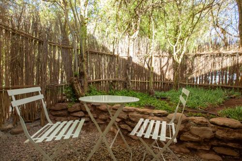 two chairs and a table and a table and a fence at Casa Solcor Boutique Bed & Breakfast in San Pedro de Atacama